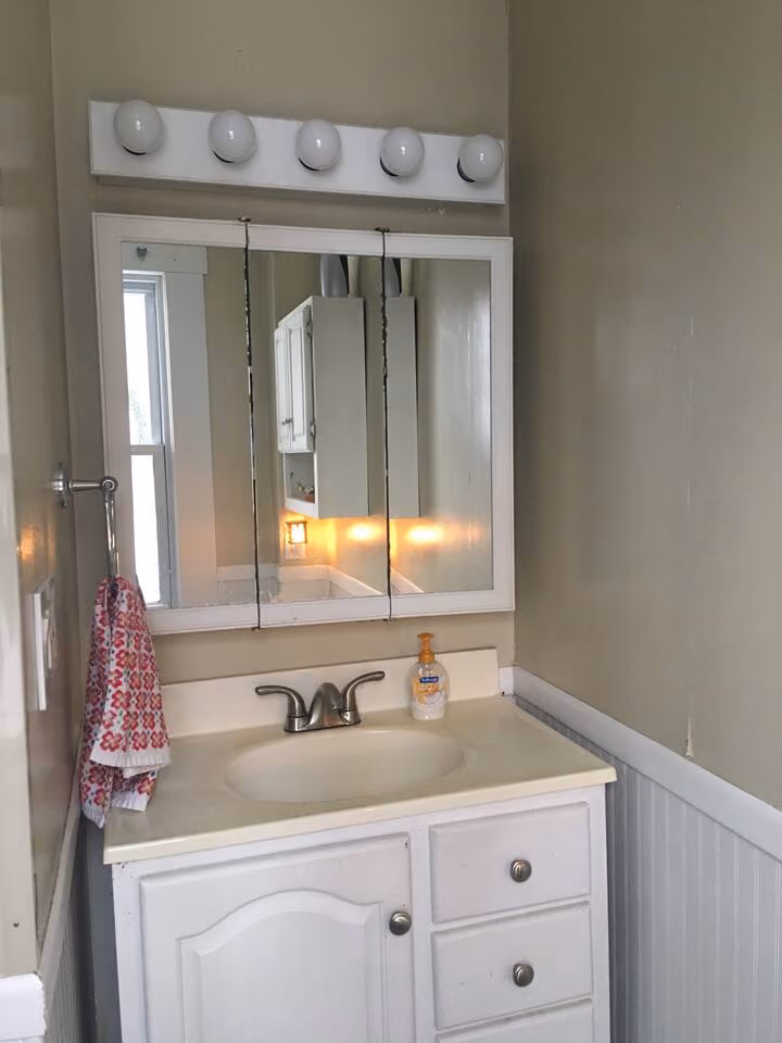 Frederick Cottage bathroom vanity with sink, mirrored cabinet, and light bar