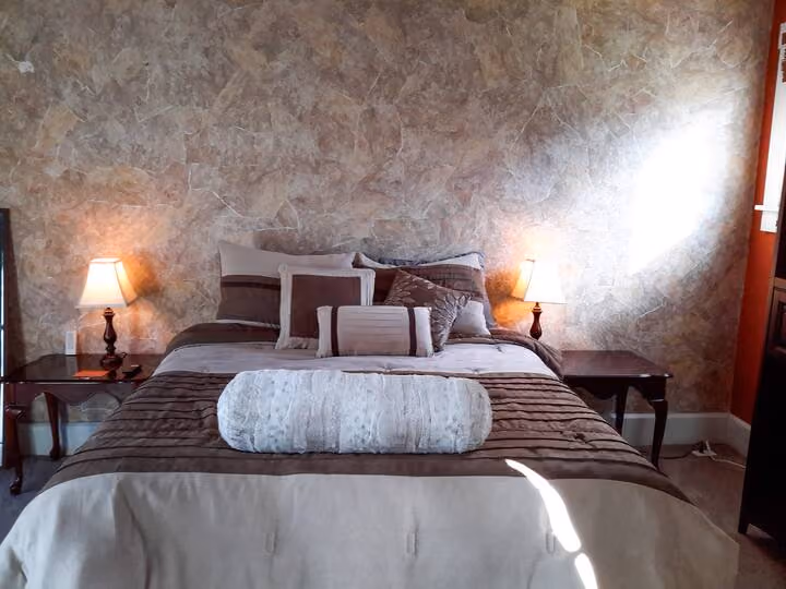 Frederick Cottage third bedroom with queen bed, lamps, and textured walls