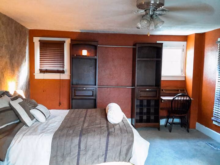 Frederick Cottage third bedroom with queen bed, shelving, desk, and windows