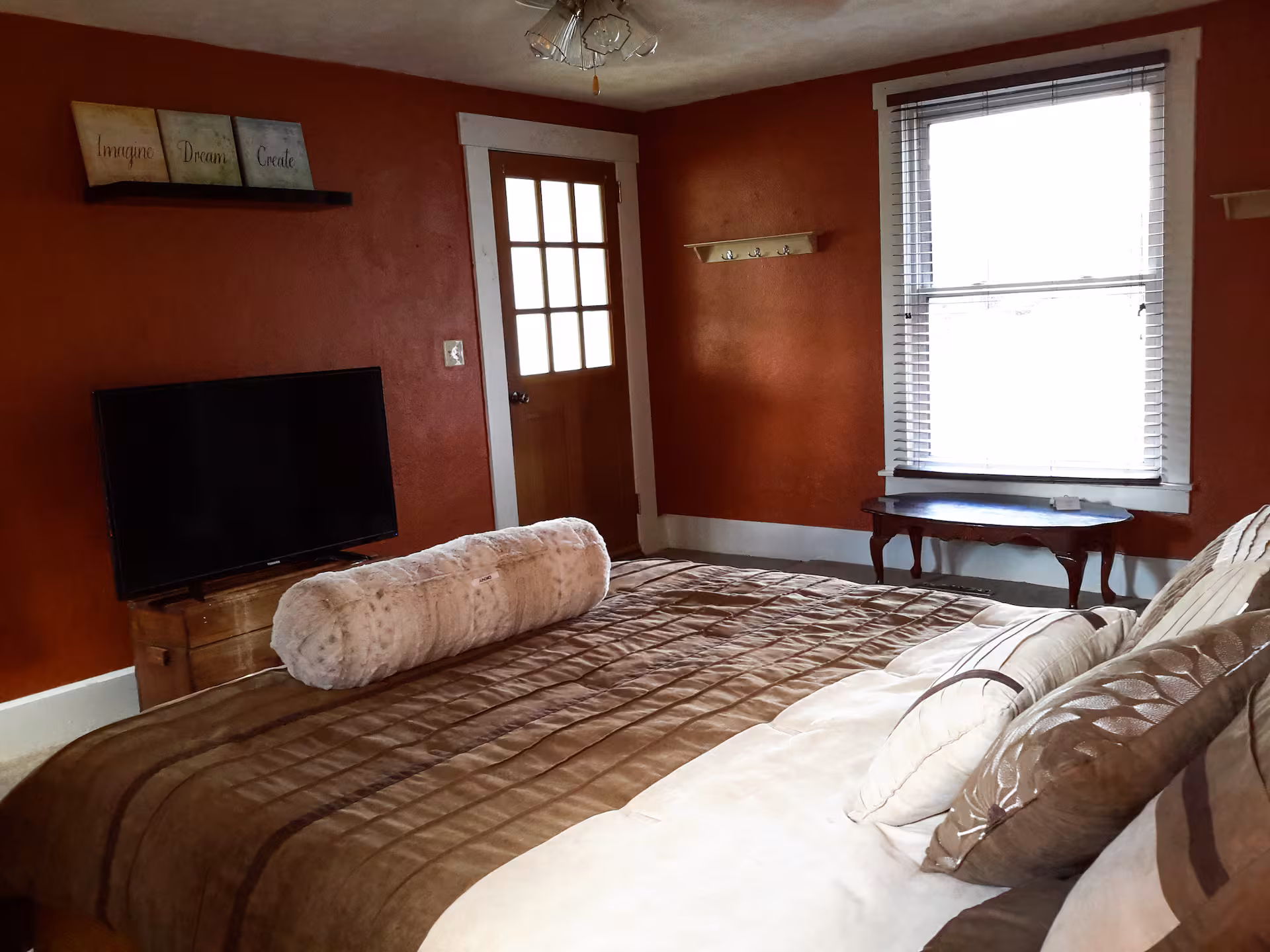Frederick Cottage third bedroom with queen bed, television, and glass-paneled door