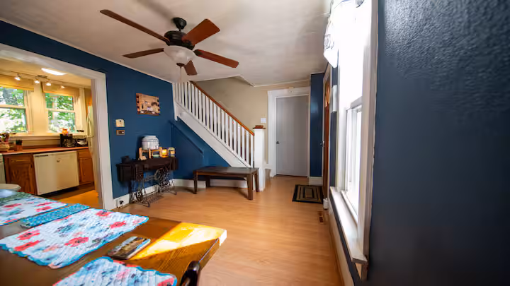 Frederick Cottage dining area opening to staircase, entry, and kitchen glimpse