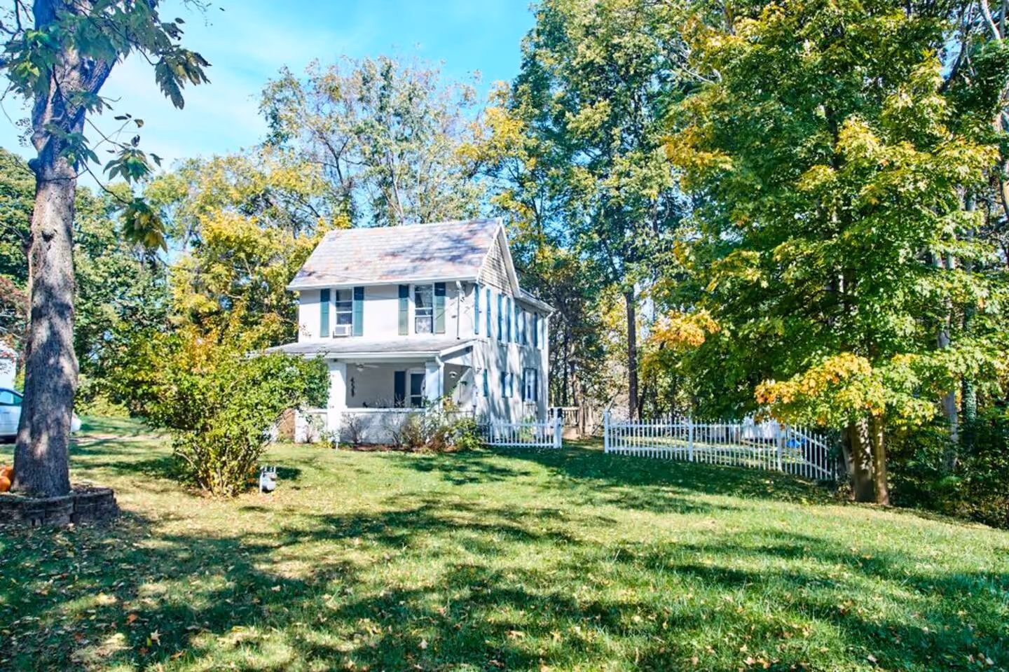 Frederick Cottage front porch with white picket fence and summer lawn