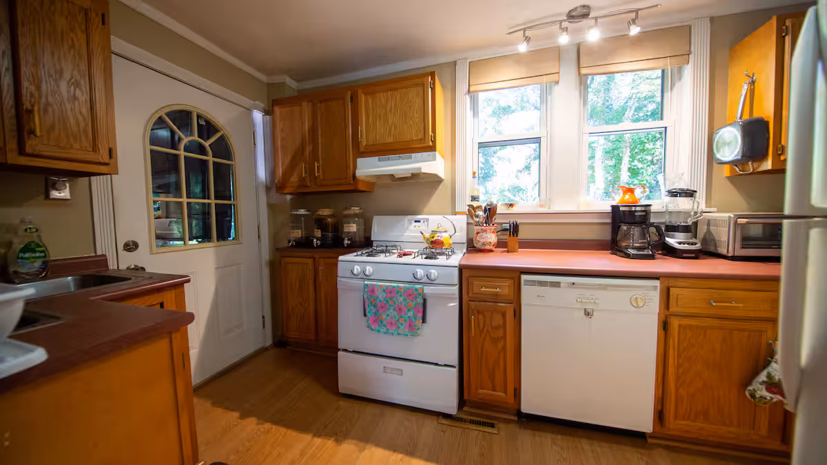Frederick Cottage full kitchen with gas range, dishwasher, sink, and oak cabinets