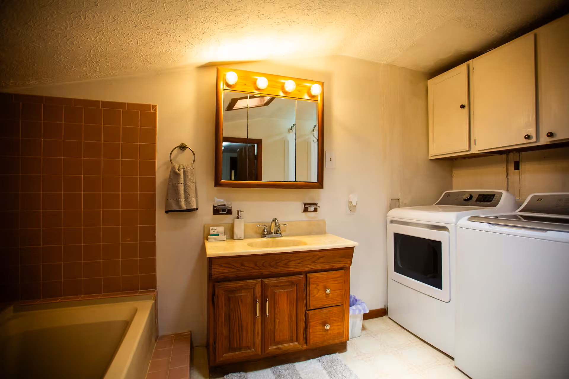 Broad Cottage combined bathroom, laundry area, vanity, and mirror