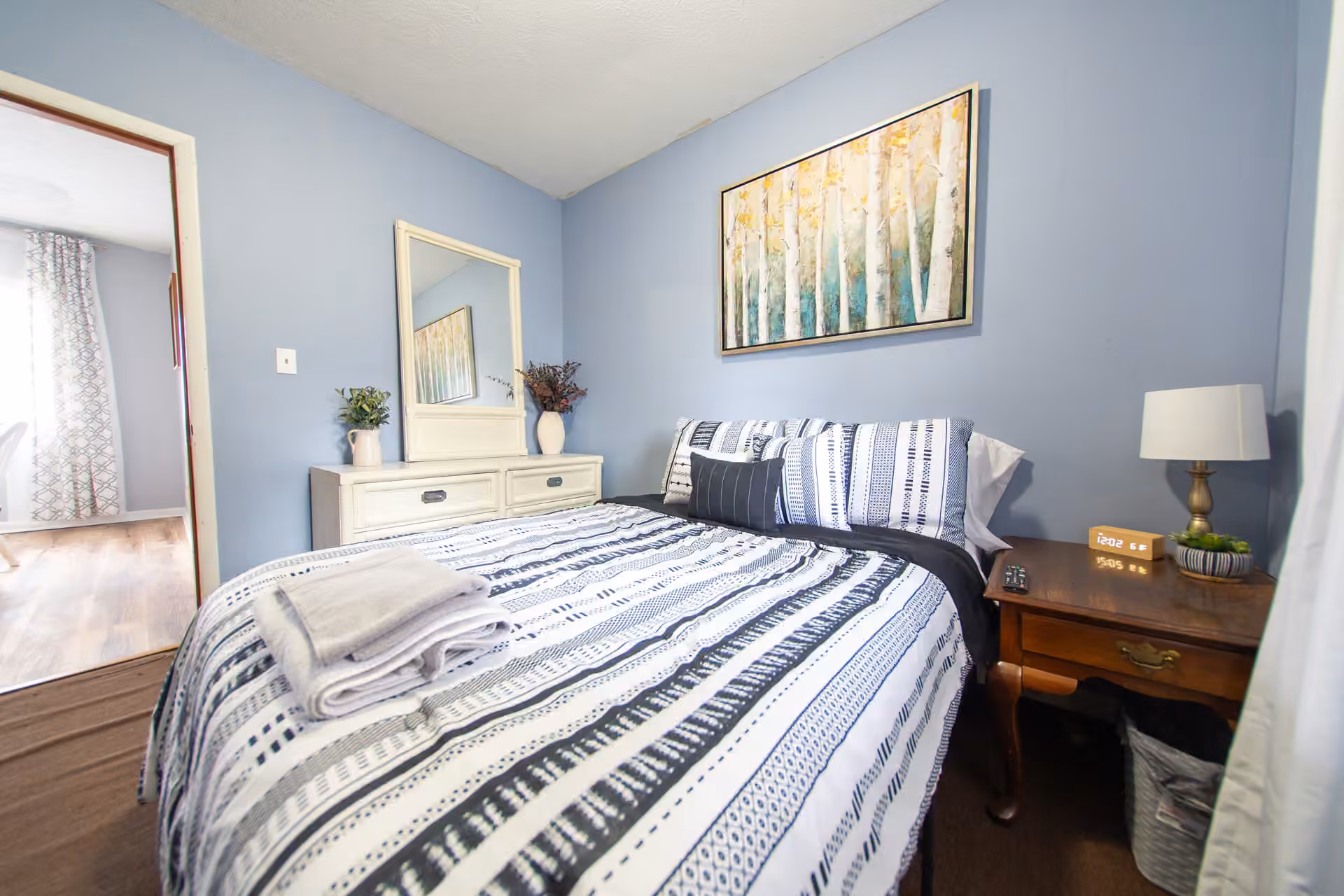 Oak Cottage bedroom with dresser, mirror, and artwork
