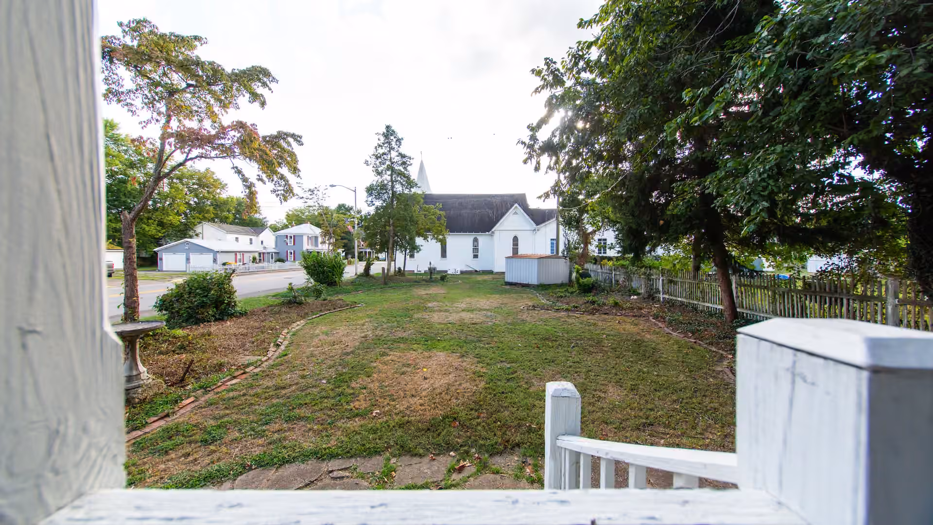 Henrietta Cottage yard with fence, lawn, and trees