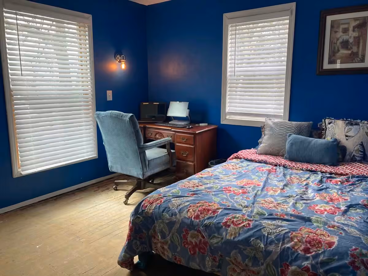 Buck Cottage bedroom with bed, desk, and windows